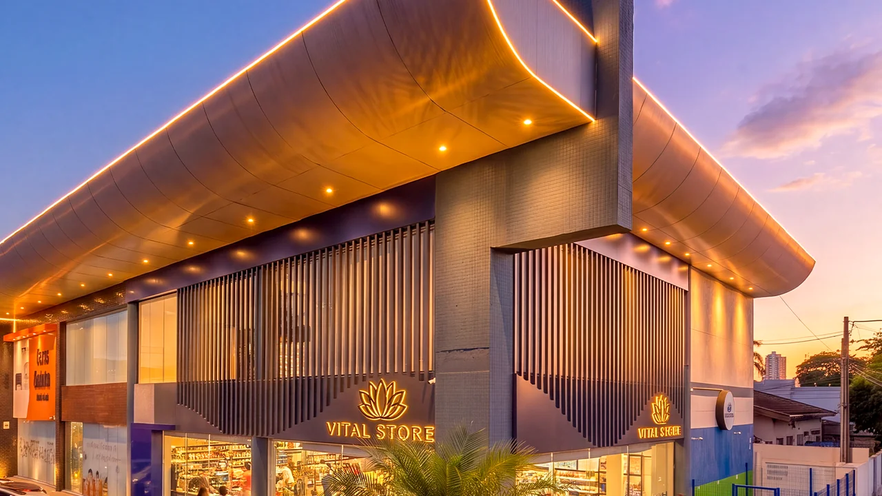 Fachada da Vital Store ao entardecer, com o letreiro aceso